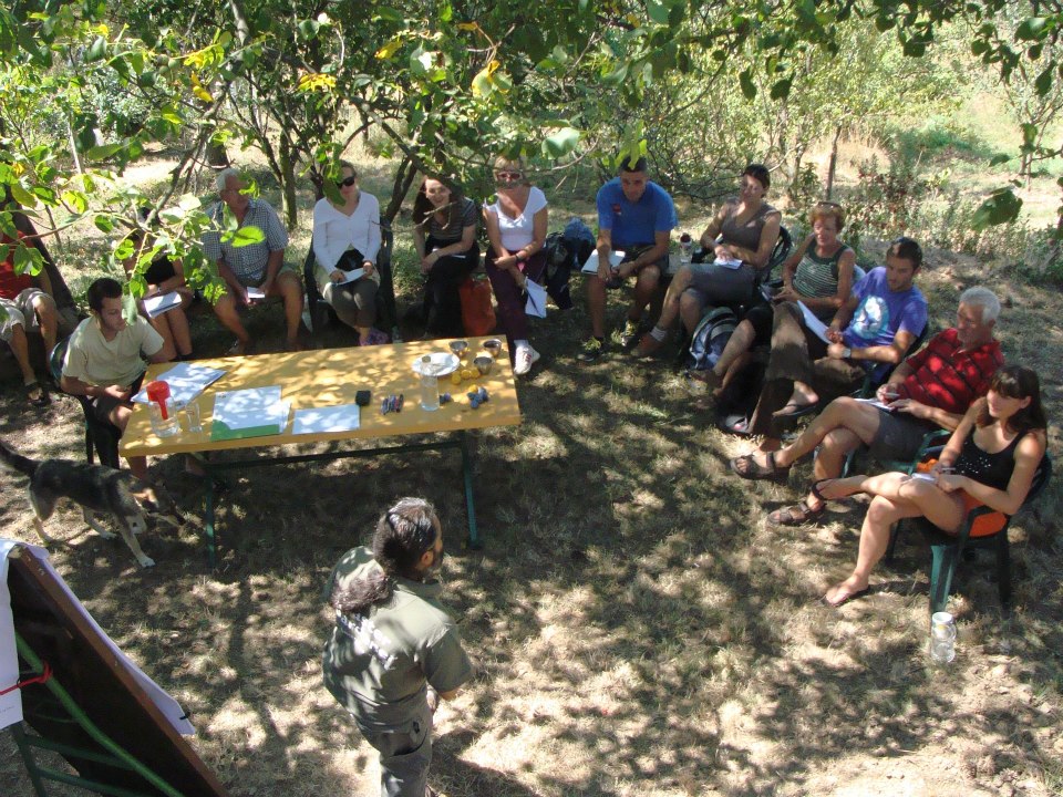 Printed permaculture design documents spread out on a table for client review and discussion